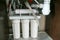 Reverse osmosis water purification system at home. Installation of water purification filters under kitchen sink in cupboard.