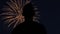 Reverse slow motion shot of silhouette of a man watching fireworks. Close-up