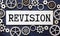 revision word made from metallic letterpress on dark jeans background