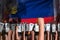 Revolt fighting concept - protest in Liechtenstein on flag background, police guards stand against the protestors crowd -