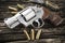 Revolver hand gun and ammunition on wooden background