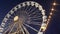 Revolving ferris wheel in night illumination on street fair