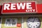 Rewe City logo sign and opening times of german supermarket chain