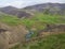 Reykjadalur valley with hot springs river, lush green grass meadow, rocks and hills with geothermal steam. South Iceland