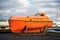 Reykjavik, Iceland - October 14, 2017: maritime safety and survival training centre boat on sea shore. Orange boat or lifeboat on