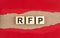 RFP word on wooden cubes on red torn paper , financial concept background