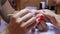 Rhinestones applying. Manicure master holding beautiful woman ring-finger .