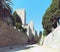 Rhodes castle view of walls battlements and towers taken from the dry moat with blue sky