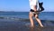 Rhodes, Greece: Ground level shot of a female / girl enjoying a barefoot walk on the rocky mediterranean beach while holding