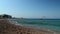 Rhodes, Greece: Wide angle pan shot of rodos beach of mediterranean sea during summer. Waves of sea on a sandy beach against clear