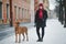 Rhodesian ridgeback with a host in the winter for a walk in the city. girl with a dog