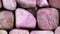 Rhodochrosite heap jewel stones filled texture on black background. Moving right seamless loop backdrop