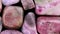 Rhodochrosite heap jewel stones filled texture on black background. Moving right seamless loop backdrop