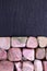 Rhodochrosite heap stones texture on half black stone background. Place for text