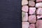 Rhodochrosite heap stones texture on half black stone background. Place for text