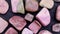 Rhodochrosite heap up jewel stones texture on black stone background. Moving right seamless loop backdrop