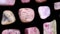 Rhodochrosite rare jewel stones texture on black background. Moving right seamless loop backdrop