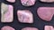 Rhodochrosite rare jewel stones texture on black stone background. Moving right seamless loop backdrop