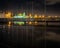 Rhythm of flagpoles, viaduct and Frikirkjan in night reflection of Tjornin pond