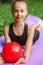 Rhythmic gymnastics. Preteen child gymnast performs an exercise with ball on sport mat