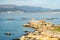 Rias Baixas seascape with Punta Cabalo lighthouse and mussel boat sailing between mussel beds called bateas. Galicia, Spain