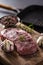 Rib Eye steak salt pepper spices garlic and mushroom. Raw beef meat on butcher board