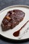 Rib eye steak on white plate, close-up. Sliced tenderloin steak