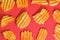 Ribbed potatoes snack with pepper on red background. Ridged potato chips on red background. Collection. Flat lay. Close