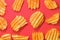 Ribbed potatoes snack with pepper on red background. Ridged potato chips on red background. Set of potato chips. Flat