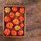 Ribbed tomatoes in a wooden tray top view. Copy space. Summer harvest tomato
