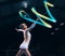 Ribbon gymnastics, woman and smile in motion blur of dancer, talent show and competition in dark arena. Happy female