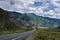 ribbon of the road among the slopes of the mountains on the expanses of Altai on a summer day