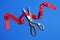 Ribbon and scissors on color background, top view