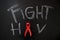 Ribbon with text of fight HIV on the blackboard