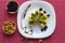 Rice biscuit with cheese and kiwi, accompanied by nuts and raisins.