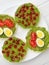 Rice cakes with avocado mash and eggs with tomato and pomegranate seeds vertical shot