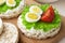 Rice cakes with cream cheese and quail eggs with lettuce and tomato close up