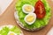 Rice cakes with cream cheese and quail eggs with lettuce and tomato top view