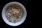 Rice congee mixed with shrimp and pork in white bowl.