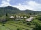 Rice fields in front of huts in Bali, jungle and mountains, view from a drone