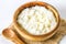 Rice milk porridge with nuts and raisins in wooden bowls on a white wooden table.