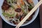 Rice noodles stir fry in bowl with ear wood mushrooms, vegetables