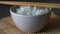 Rice in a porcelain bowl, with Japanese chopsticks, soy sauce, served on a gray stone table Close up