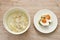 Rice porridge with chop pork dressing soy sauce soup in bowl eat couple boiled spicy salty egg half cut topping slice shallot and