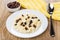 Rice porridge with milk, raisins, bowl with raisin, spoon