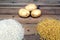 Rice, potatoes and macaroni pasta on a wooden table.Three common carbohydrates which provide energy but can cause obesity