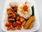rice with side dishes, fried tempeh, french fries with chilies and baby squid with chilies.