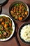 Rice and stir fried beef with vegetables in plates on wooden background