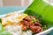 Rice topped with stir-fried pork, basil leaves and chili served