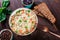 Rice with vegetables, peas, carrots, peppers on plate on wooden background.